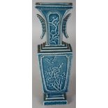 A CHINESE BLUE GLAZED MOULDED PORCELAIN VASE, the sides with panels of foliage and of characters,