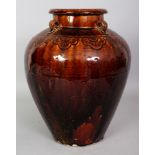 A CHINESE MING STYLE STORAGE JAR, applied with a brown ochre glaze, the shoulders with four lug