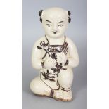 A CHINESE MING STYLE CIZHOU CERAMIC FIGURE OF A KNEELING BOY, the details in brown reserved on a