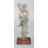 A 20TH CENTURY CHINESE JADE FIGURE OF A STANDING LADY, together with a fitted wood stand, the lady