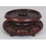 A 19TH/20TH CENTURY CHINESE CARVED HARDWOOD VASE STAND, with lotus form feet, 4.5in wide at widest