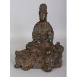 A CHINESE BRONZED METAL MODEL OF GUANYIN, seated on a buddhistic lion, the reverse and the base each