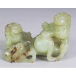 A CHINESE CELADON JADE GROUP, modelled in the form of three Buddhistic lions playing with a ribboned