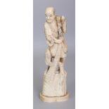 A JAPANESE MEIJI PERIOD MARINE IVORY OKIMONO OF A FISHERMAN, standing on rockwork and hauling in a