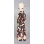 AN EARLY 20TH ORIENTAL STAINED IVORY FIGURE OF A STANDING PRIEST, bearing a censer from which