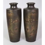 A SIGNED MIRROR PAIR OF EARLY 20TH CENTURY JAPANESE MIXED METAL VASES, each decorated with a scene