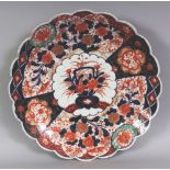 AN EARLY 20TH CENTURY JAPANESE IMARI FLUTED PORCELAIN DISH, with a wavy rim, 13.25in diameter.