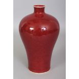 A CHINESE COPPER RED MEIPING PORCELAIN VASE, applied with a slightly mottled glaze, the base with