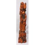 A LARGE CHINESE WOOD FIGURE OF SHOU LAO, standing on a rockwork plinth and leaning on his staff,