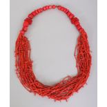 A LARGE CORAL TYPE BEAD NECKLACE, composed of two cinnabar lacquer beads, large circular coral-style