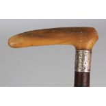 A RHINO HORN HANDLED & KNARLED WOOD WALKING STICK, with a hallmarked and engraved silver collar, the