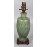 A CHINESE MING DYNASTY LONGQUAN CELADON VASE, fitted for electricity, the sides carved beneath the