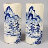 A PAIR OF CHINESE BLUE & WHITE CYLINDRICAL PORCELAIN VASES, each decorated with a river landscape