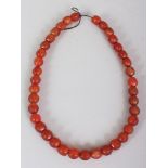 AN AGATE NECKLACE, composed of hexagonal section oval beads, approx. 20.5in long.