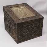 AN EARLY 20TH CENTURY INDIAN CARVED WOOD RECTANGULAR CHEST, the sloping hinged lid inset with an