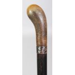 A RHINO HORN HANDLED WOOD CANE, with a plain hallmarked silver collar, the shaped rhinoceros horn