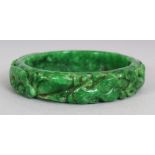 ANOTHER SMALLER CHINESE APPLE GREEN JADE BANGLE, the outer rim similarly carved, 2.9in diameter, the