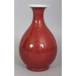 A CHINESE COPPER RED YUHUCHUNPING PORCELAIN VASE, applied with a faintly mottled glaze, the base