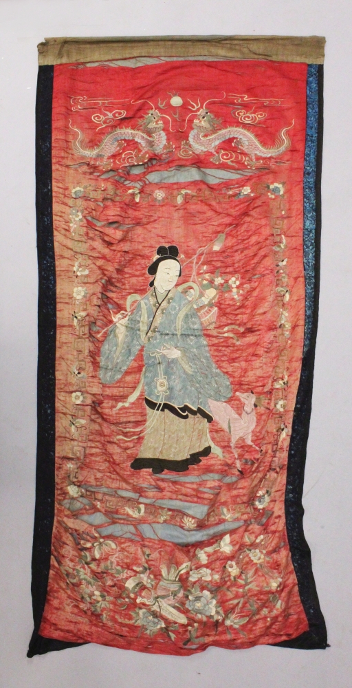 A 19TH CENTURY CHINESE RED GROUND EMBROIDERED SILK WALL HANGING, decorated with the Immortal Lan