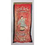 A 19TH CENTURY CHINESE RED GROUND EMBROIDERED SILK WALL HANGING, decorated with the Immortal Lan