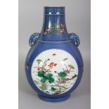 A CHINESE FAMILLE VERTE POWDER-BLUE GROUND PORCELAIN HU VASE, with elephant-head handles, the