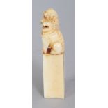 A GOOD QUALITY EARLY 20TH CENTURY IVORY SEAL-FORM CARVING, in the form of a Buddhistic lion seated
