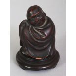 A SMALL EARLY 20TH CENTURY CHINESE WOOD FIGURE OF A SLEEPING PRIEST, together with a wood stand, the