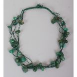 A GREEN HARDSTONE MULTI-STRAND NECKLACE, composed of irregularly formed beads.