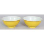 A PAIR OF CHINESE YELLOW GLAZED PORCELAIN BOWLS, each with an everted rim, each base with a four-