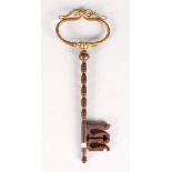 AN UNUSUAL KEY with gilt scrolled handle. 8ins long.