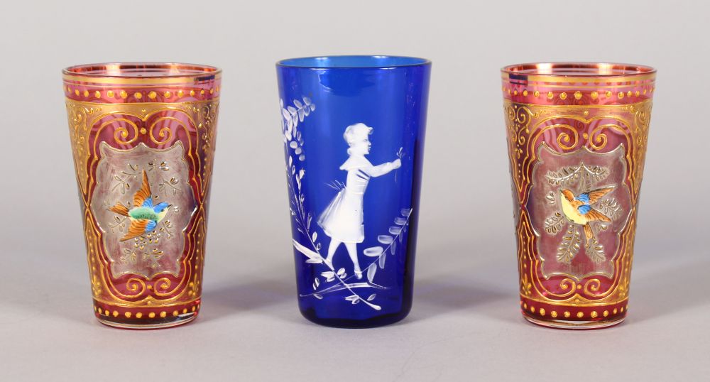 A SMALL PAIR OF RUBY GILT BEAKERS, encrusted with birds, 3ins high, and A MARY GREGORY BLUE