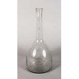 A LARGE EARLY PLAIN GLASS BOTTLE. 15ins high.