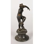 AFTER THE ANTIQUE A GOOD BRONZE OF A NUDE, standing on one leg adjusting her sandals, a dolphin