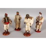 A SET OF FOUR INDIAN PAINTED AND CLOTHED FIGURES on circular bases. 8.5ins high.