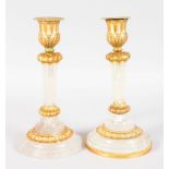 A GOOD PAIR OF ROCK CRYSTAL ORMOLU MOUNTED CIRCULAR CANDLESTICKS. 7.75ins high.