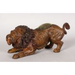 A COLD PAINTED BRONZE PEN WIPE, modelled as a crouching lion. 6.5ins long.