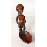 A CARVED WOOD TRIBAL SPOON. 9ins.