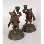 A PAIR OF COLD PAINTED BRONZE CANDLESTICKS, modelled as a fox and a bear drinking and gambling. 7ins