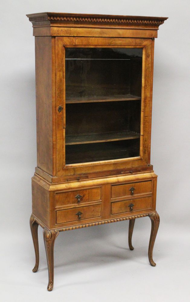 AN 18TH CENTURY WALNUT GLASS FRONTED CUPBOARD on a later stand, with two candle slides and four