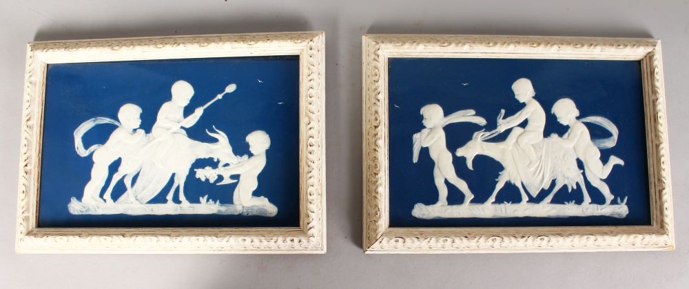 A GOOD PAIR OF FRAMED BLUE AND WHITE PATE SUR PATE PLAQUES, signed, Possibly MINTON, cupid with a