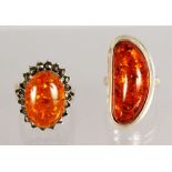 TWO SILVER AND AMBER RINGS.