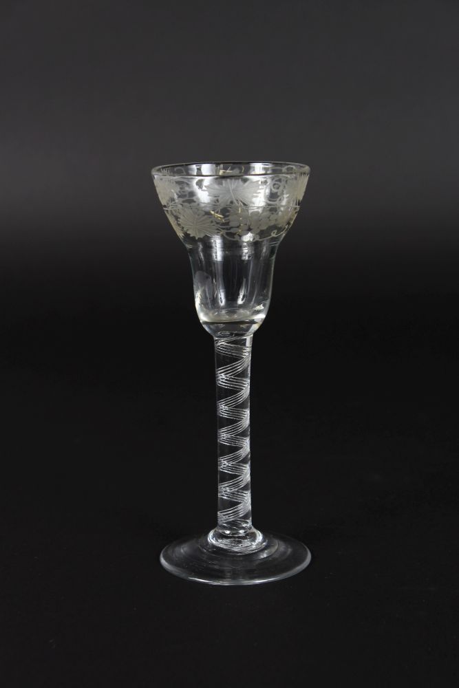 A GEORGIAN WATER GLASS with air twist stem, bowl engraved with fruiting vines. 6ins high.