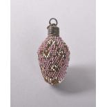 A MINIATURE BEADWORK PERFUME BOTTLE with white flowers and a deep pink ground. 3.5cms.