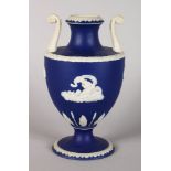 AN ADAMS BLUE AND WHITE JASPER WARE CLASSICAL TWO HANDLED URN, with white motifs on a blue ground.