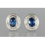 A PAIR OF 14K WHITE GOLD AND DIAMOND EARRINGS SET WITH OVAL CUT BLUE SAPPHIRES, approx. 2ct total