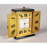 A VERY GOOD CARTIER TRAVELLING CLOCK with pair of open doors and cabochon stone handle. 5.5cms high,