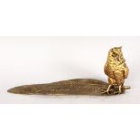 AN AMUSING BRONZE INKWELL, modelled as an owl standing on a feather. 1ft 2ins long.