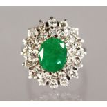 A VERY NICE 18CT WHITE GOLD, EMERALD AND DIAMOND CLUSTER RING.