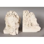 A PAIR OF RECONSTITUTED MARBLE BOOKENDS, modelled as lions, the bases inset with medallions. 5ins