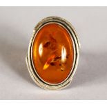 A SILVER AND AMBER RING.